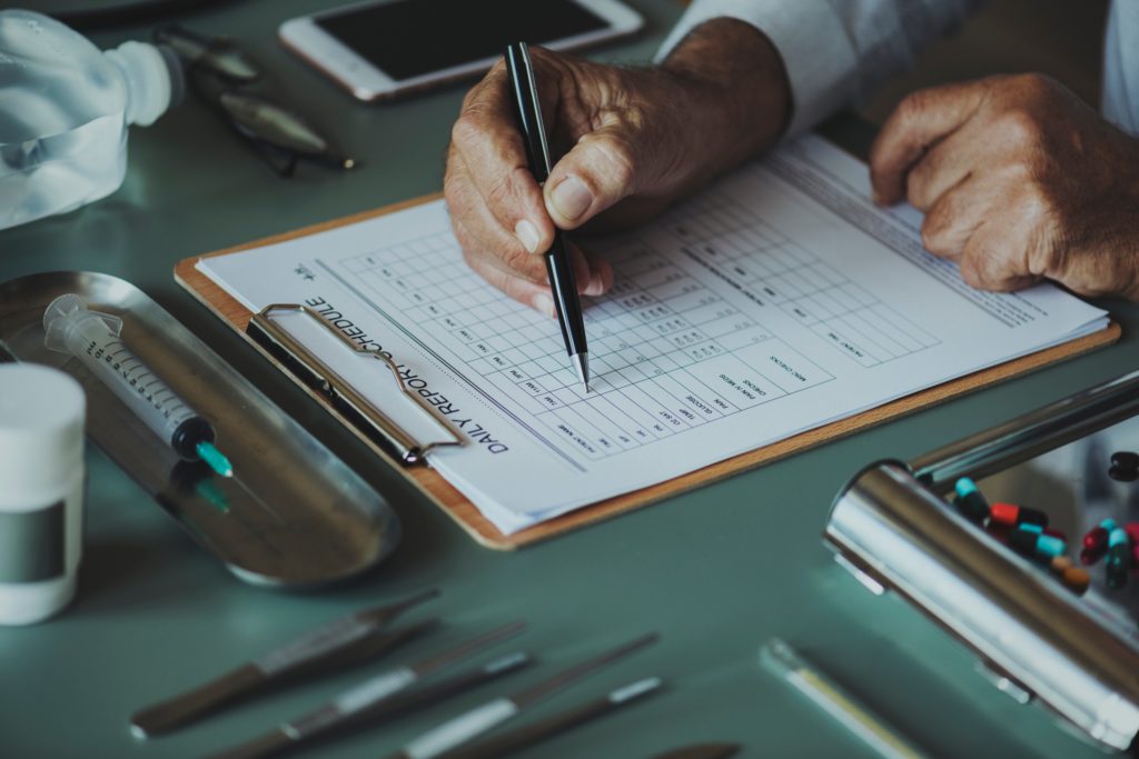 paperwork on clipboard and someone completing it